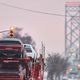 Trucks drive down the road towards the Ambassador Bridge border crossing in Windsor, Ontario, on February 14, 2022. - Trucker-led demonstrations against Canada’s COVID-19 restrictions disrupted traffic on the Ambassador Bridge for seven days, but authorities on February 13, 2022, cleared out the protestors.